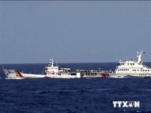 A Chinese vessel (right) is ready to harass Vietnamese fisheries surveillance ship (Photo: VNA)